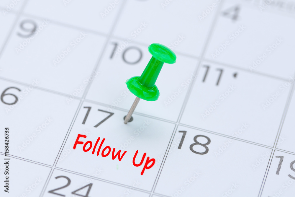 Follow Up written on a calendar with a green push pin to remind you and