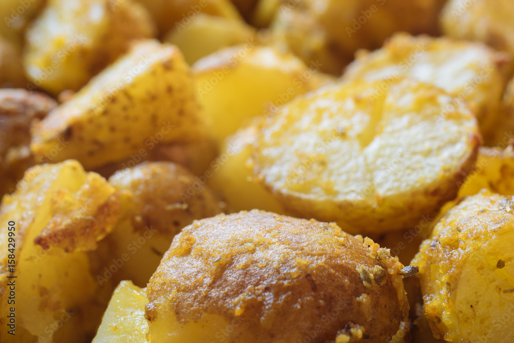 Closeup on baked potatoes with curcuma and other spices