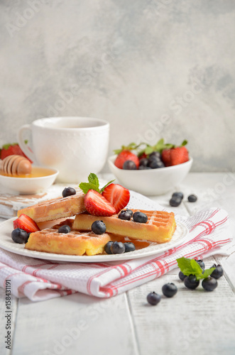 Waffles with fresh berries on rustic wooden background  selective focus
