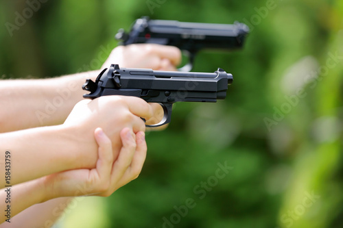 Young boys practice shooting guns on outdoor