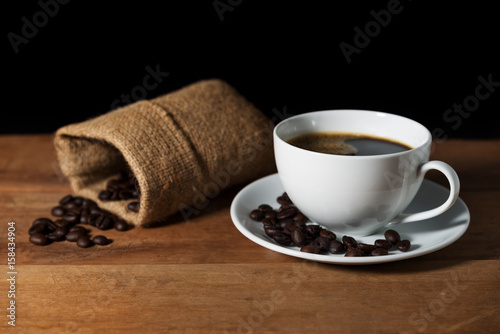 Coffee cup with coffee bean on brown wooden table