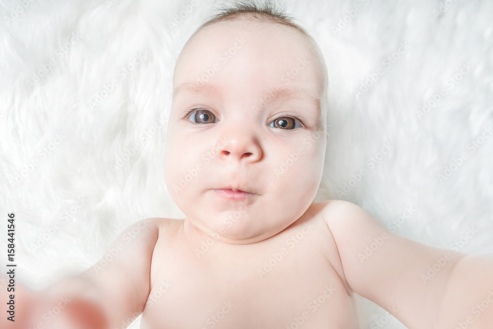 Cute baby lies on a white fluffy background Cute baby lies on a white fluffy background