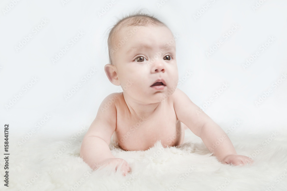 Cute baby lies on a white fluffy background Cute baby lies on a white fluffy background