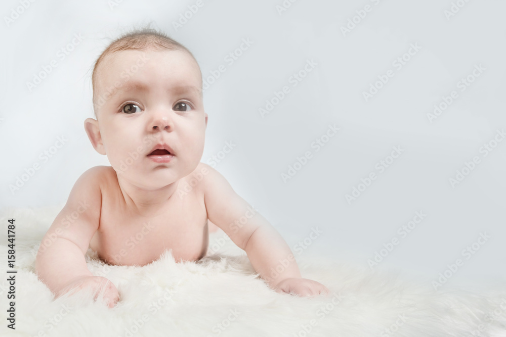 Cute baby lies on a white fluffy background Cute baby lies on a white fluffy background