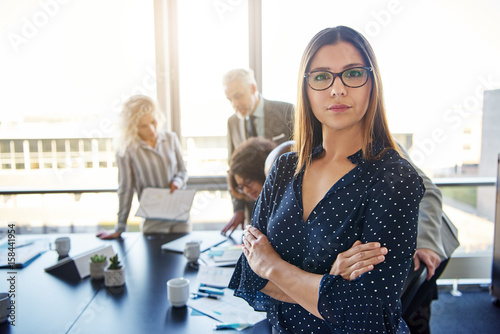 Canvas Print Serious business woman in front of team