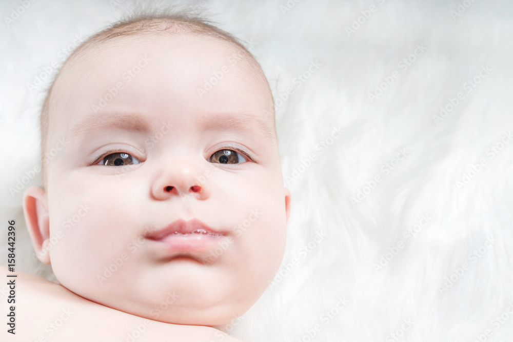 Cute baby lying on a white fur Cute baby lying on a white fur