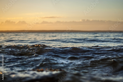 smooth ocean waves under soft cloudy sky off martha's vineyard coast