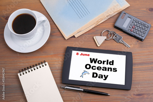 8 June World Oceans Day. Text on tablet device on a wooden table.