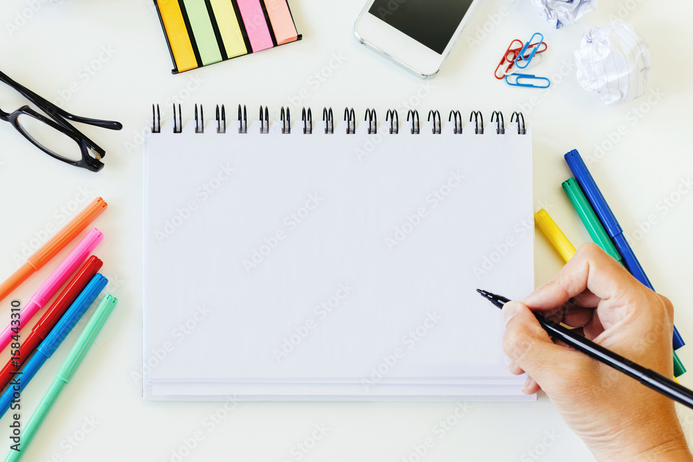 Office stuff and gadgets display on top view business desk with blank copy space for text on white notebook Still life and financial concept.
