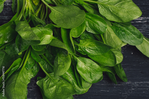 Fresh juicy spinach on a dark background. Food background with eco spinach. Ecological food