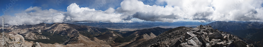 panorama of billowing clouds above rocks panorama of billowing clouds above rocks