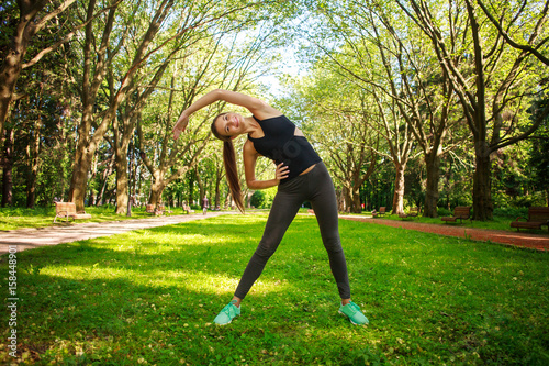 Young woman doing fitness exercises in park