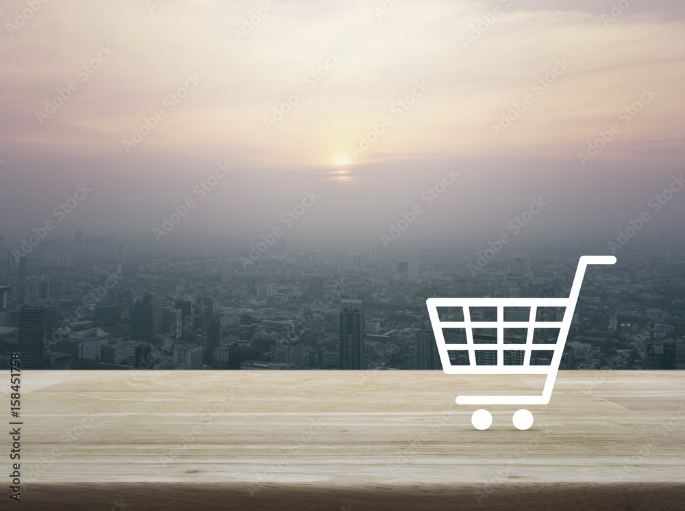 Shopping cart icon on wooden table over aerial view of cityscape at sunset, vintage style, Shop online concept Shopping cart icon on wooden table over aerial view of cityscape at sunset, vintage style, Shop online concept
