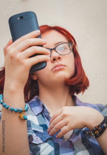 Fashion pretty young girl makes selfie portrait on smartphone.