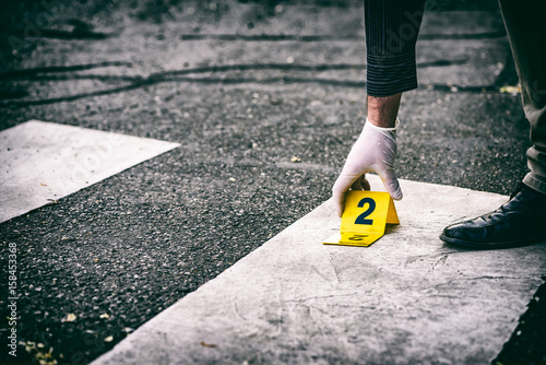 Putting the crime scene marker on the asphalt photo