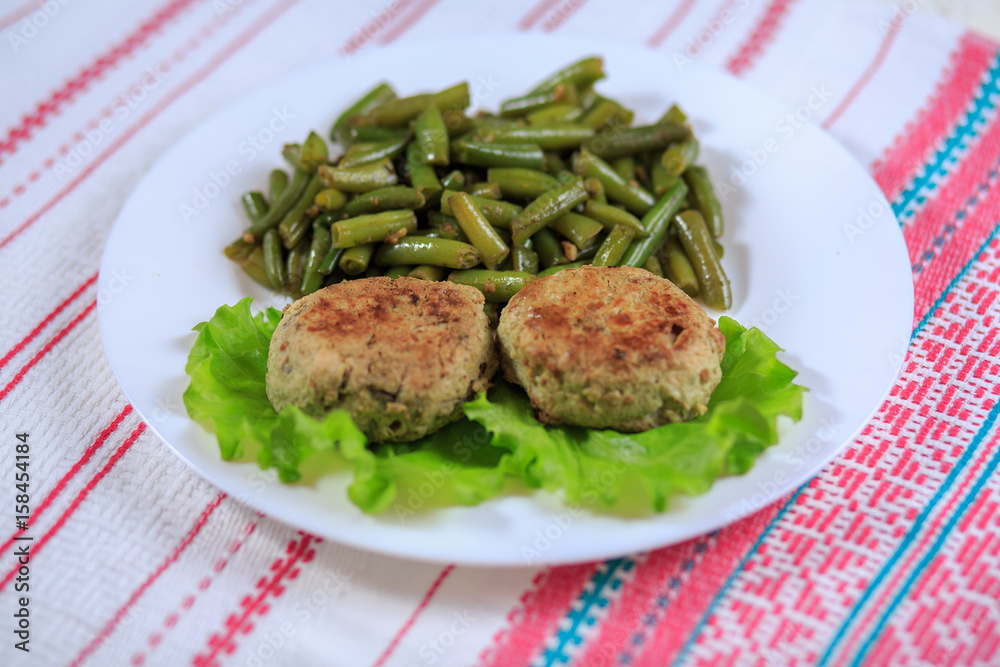 Cutlets with a stuffing with a garnish on a white plate on a light background