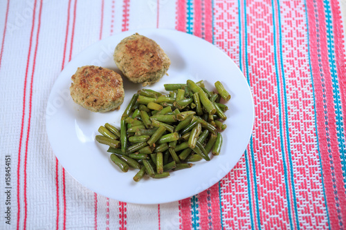 Cutlets with a stuffing with a garnish on a white plate on a light background photo