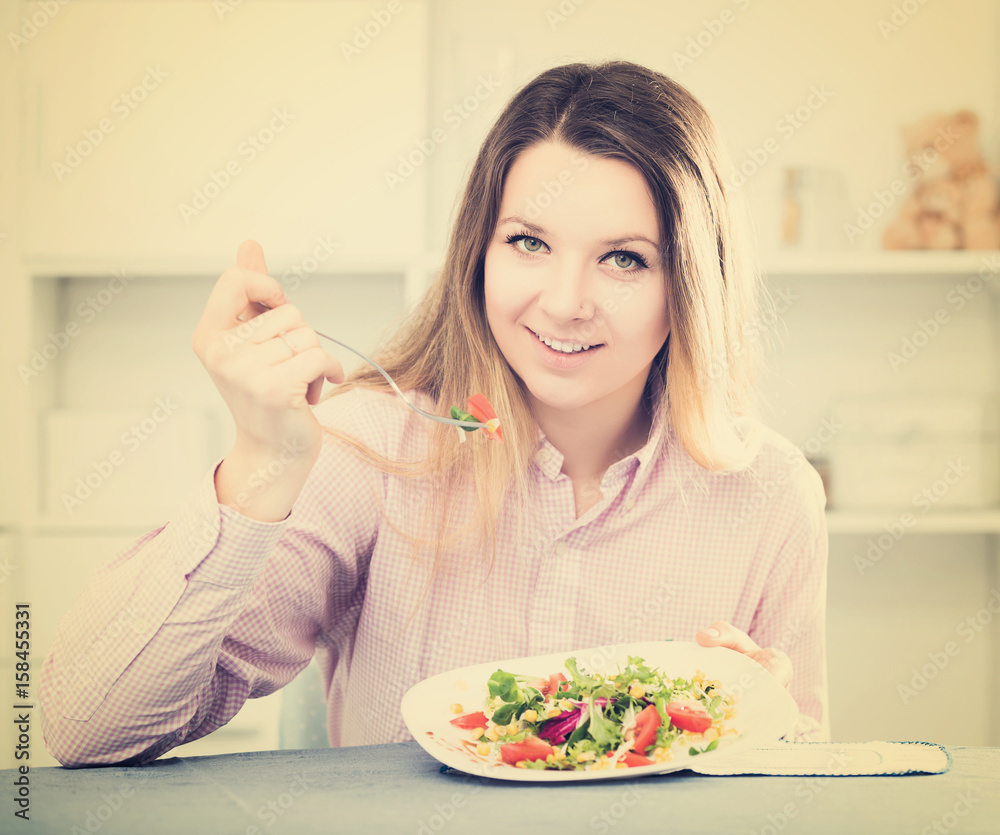 Woman tasting fresh green salad