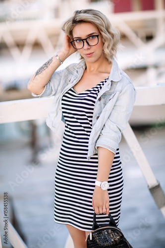 portrait of a young woman, blonde, glasses, outdoors in the park © boykovi1991