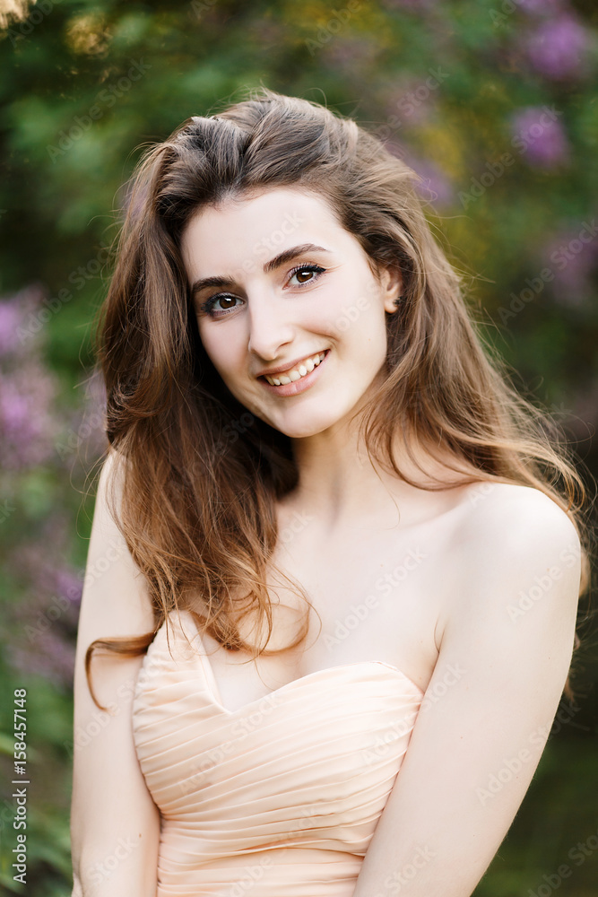Naklejka premium Portrait of a Beautiful Girl Laughs in the Spring Garden