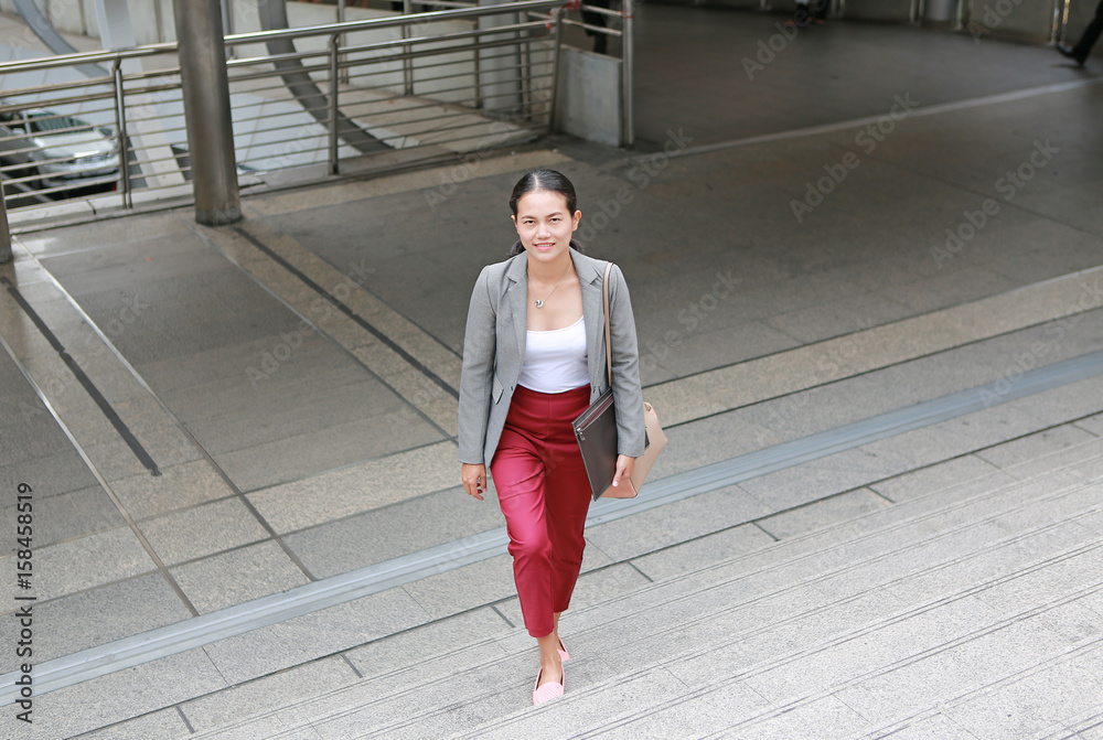 Fototapeta premium young business woman walking outside. Asian businesswoman office worker in downtown business district. 