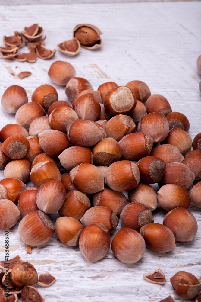 Brown Hazelnuts on white wooden background in studio photo. Healhty snacks Brown Hazelnuts on white wooden background in studio photo. Healhty snacks