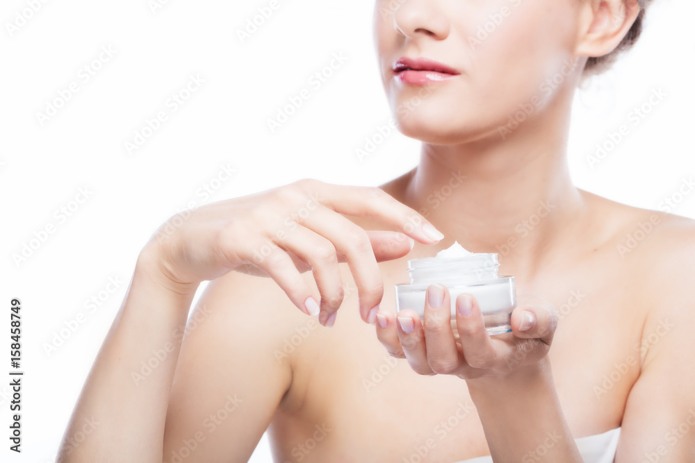 Young, attractive woman using a moisturizer. Young, attractive woman using a moisturizer.