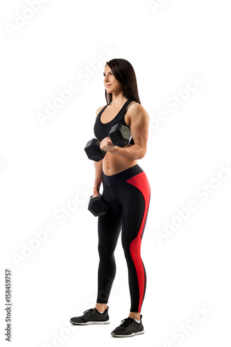 Young athletic woman fitness model doing an exercise with a dumbbell, one arm in a position underneath, a second in a half-bent state, on a white isolated background