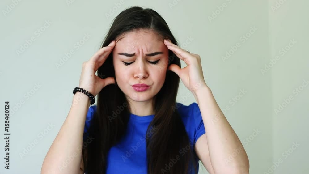 Beautiful young woman touching her head, feeling sick with a severe headache