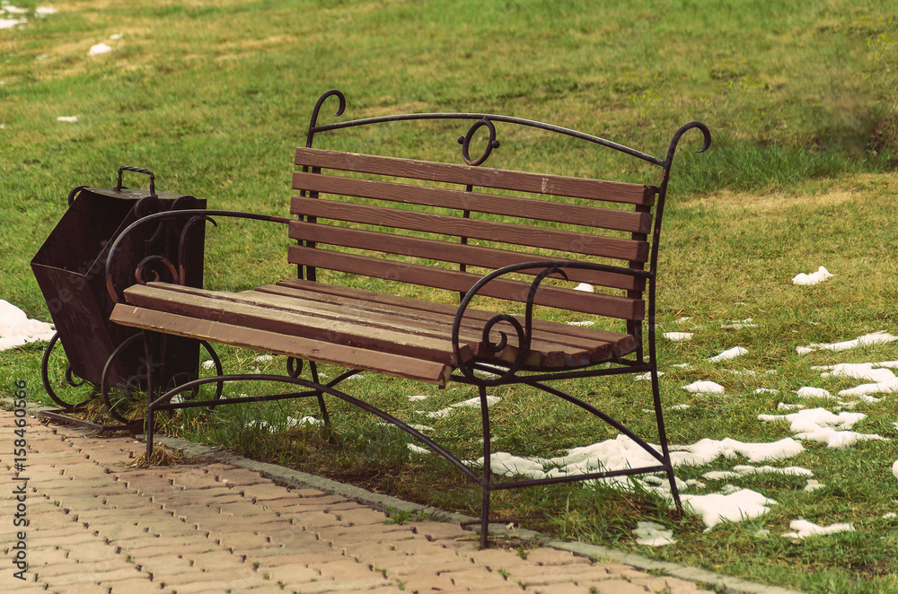 Forged bench and urn in the park toned Forged bench and urn in the park toned