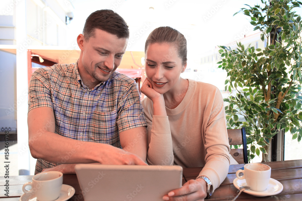 Flirting couple in cafe using digital tablet. Flirting couple in cafe using digital tablet.
