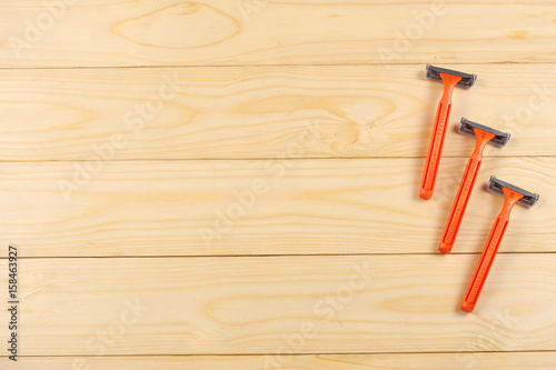 Shaving razor on wooden background.top view with copy space