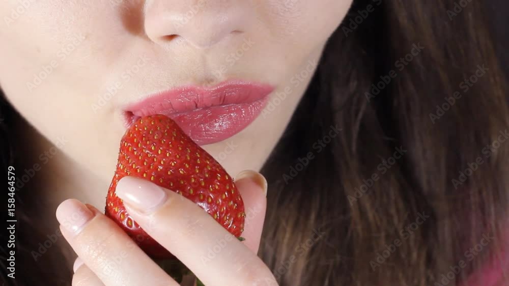 Sexy Woman Eating Strawberry in slowmotion. Sensual Red Lips. Red Manicure and Lipstick. Sexy Woman Eating Strawberry in slowmotion. Sensual Red Lips. Red Manicure and Lipstick.