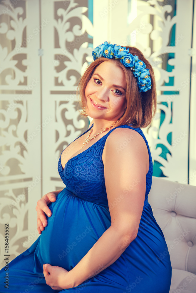 Beautiful pregnant woman in a blue dress.