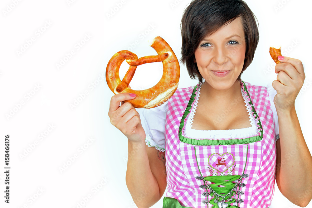 junge Frau im Dirndl isst eine Brezel junge Frau im Dirndl isst eine Brezel