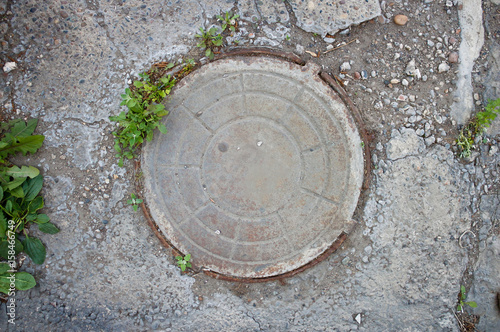 Old metal manhole. Closeup. The view from the top