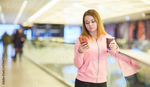 girl with the phone and coffee in the mall