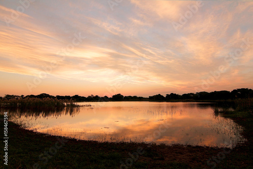 African sunset in Zululand over lake water reflections