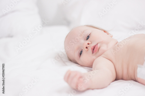 portrait of Cute baby in white bed