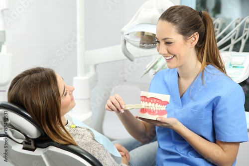 Dentist explaining how to brush teeth photo