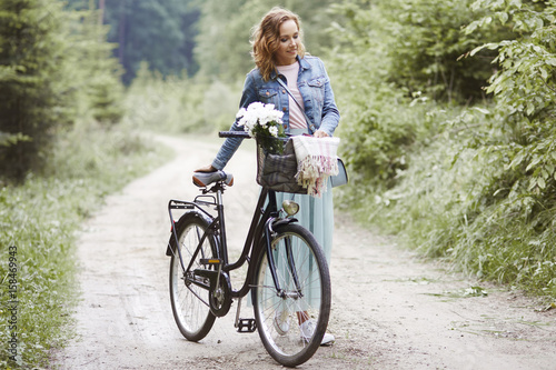 Woman with bike walking in forest