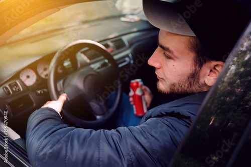 Man drinking beer while driving car