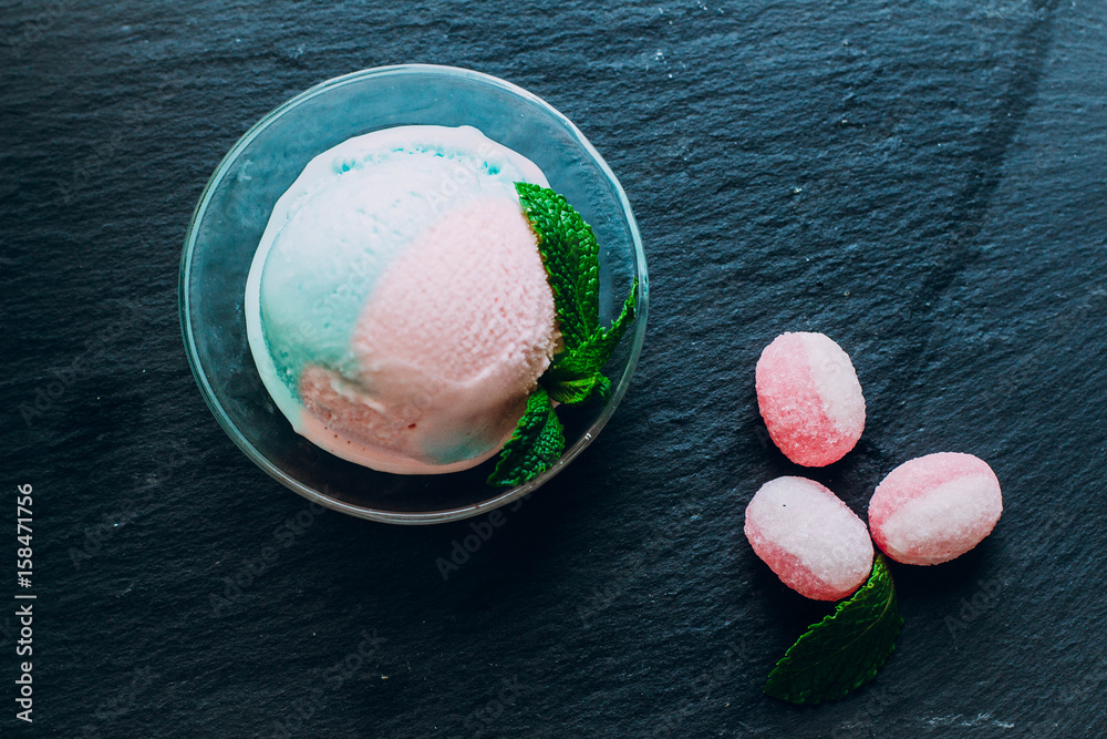Blue and pink bubble gum ice cream with sweet candy cane and mint on