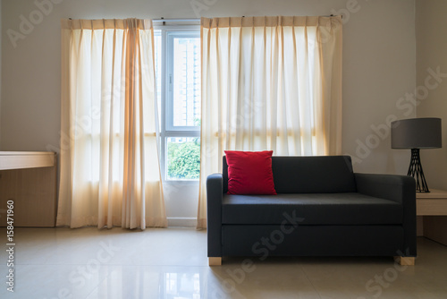 modern living room design with sofa and red Pillow on curtain and windows.