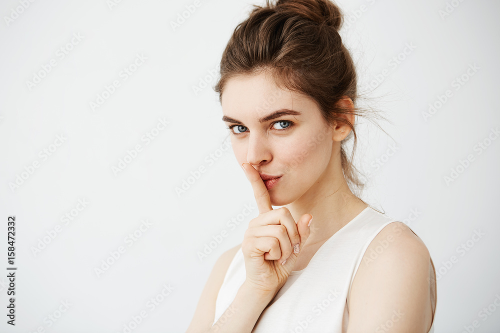Portrait of young beautiful girl showing keep silence looking at camera over white background. Portrait of young beautiful girl showing keep silence looking at camera over white background.