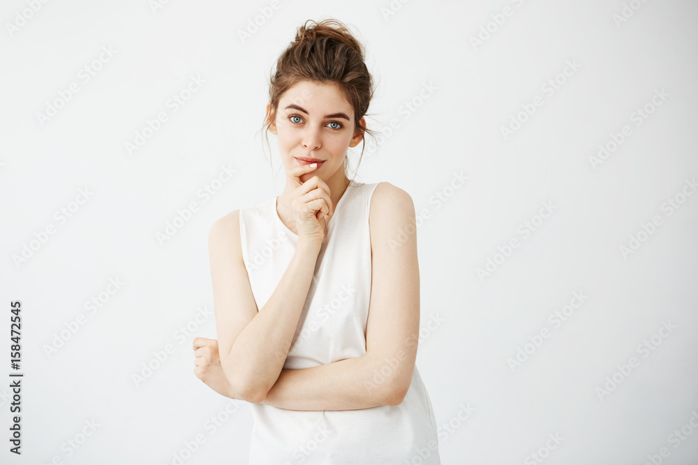 Portrait of young beautiful girl smiling looking at camera touching her chin over white background. Portrait of young beautiful girl smiling looking at camera touching her chin over white background.