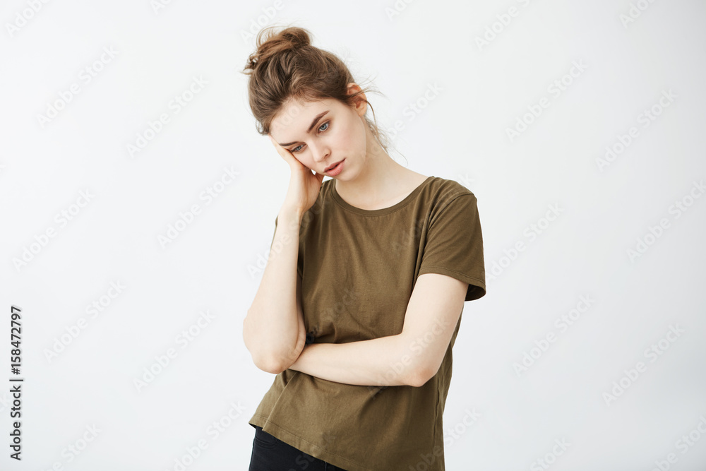 Portrait of displeased bored tired girl with bun over white background. Portrait of displeased bored tired girl with bun over white background.