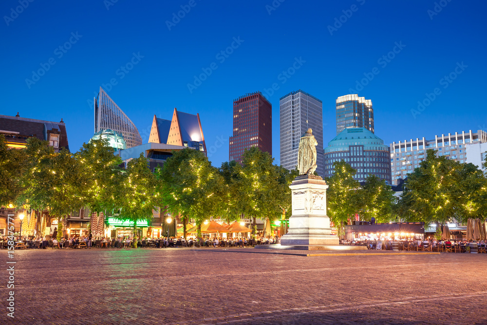 Square with William the Silent and Ministry of Security and Justice skyscraper on background on evening, The Hague