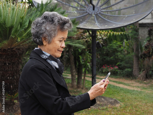 Asian elderly womam by mobile smart phone photo