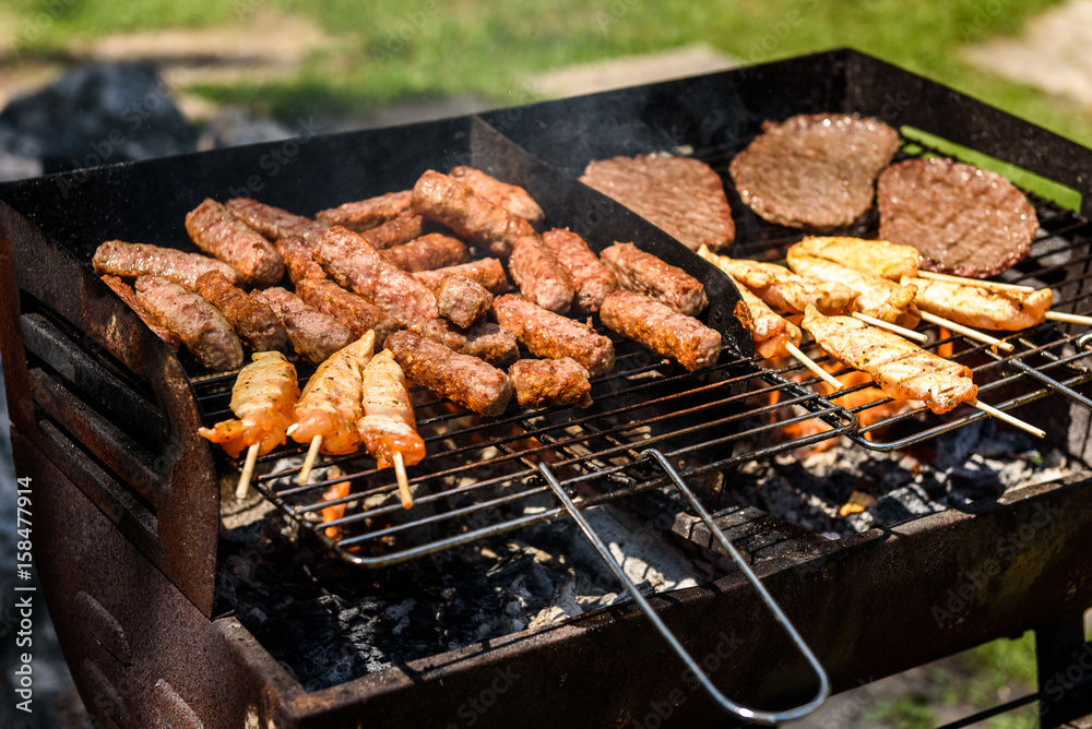 Delicious meat on barbecue grill with coal outdoors picnic.